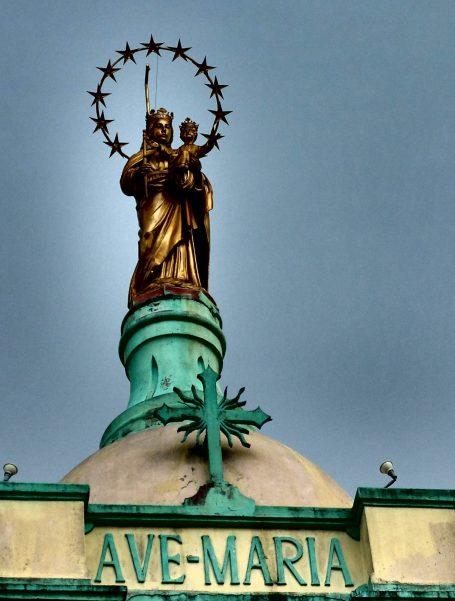 Goldene Statue der Jungfrau Maria mit Kind, umgeben von einem Heiligenschein. Schriftzug "AVE MARIA".