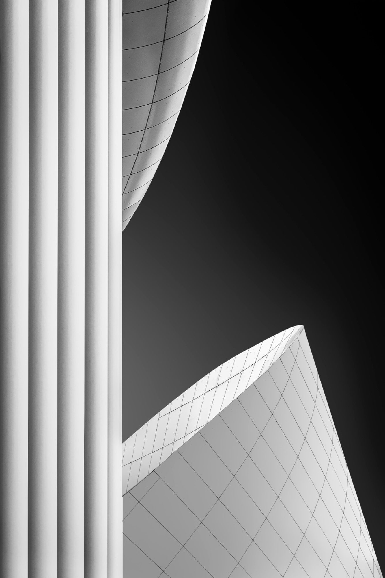 Bild des Monats Moderne, geschwungene Architektur mit dunklem Himmel im Hintergrund.