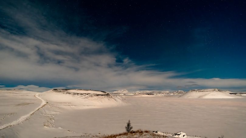 Wüstenlandschaft mit schneebedecktem Boden und weitem, klarem Himmel.